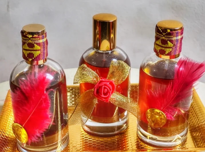 Trio of decorated perfume oil bottles on a gold tray